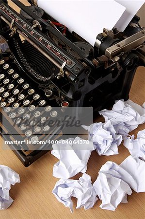 Retro typewriter with paper scattered all around - conceptual image for creative block