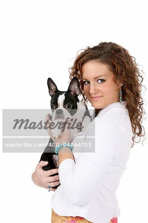 Pretty teenage girl holding a Boston Terrier; against a high key background.