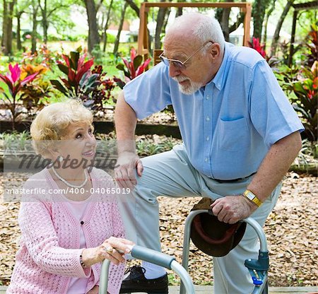 Senior man flirting with beautiful senior lady in the park.