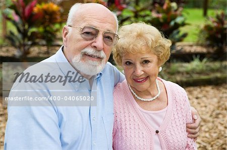 Beautiful senior couple together in their garden.  Focus on her.