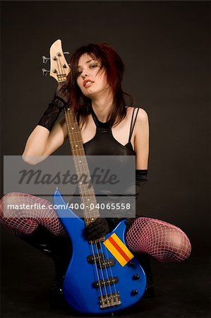 Beautiful girl with bass guitar, studio shot