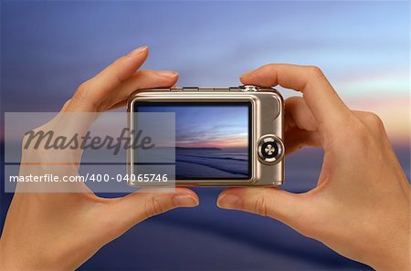 female hands taking picture with a compact digital camera