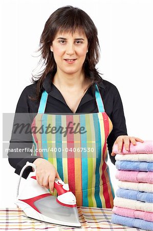 A housewife in apron holding a eletric iron close to towels stacked