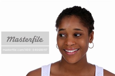 Head and shoulders portrait of a pretty African American teen looking sideways and smiling.