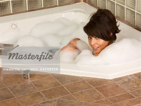 Femme sexy attirante et relaxante dans un bain de bulles chaude