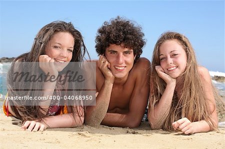 three happy teenagers having fun on the beach