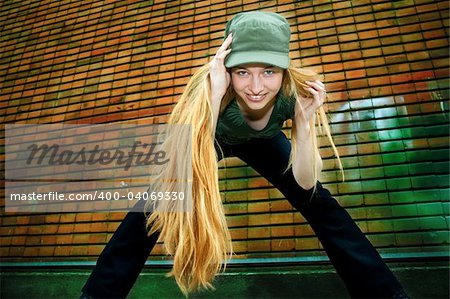 Happy girl with long blond hair - brick wall as background