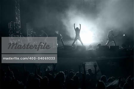 Concert: silhouette of rock singer in front of ecstatic crowd
