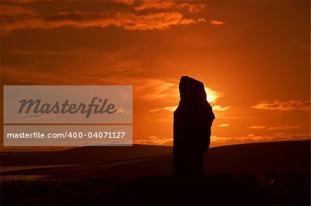 A silhouetted stone of the Ring of Brodgar during sunset