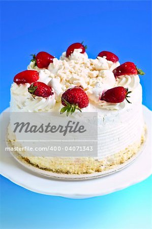 Strawberry meringue cake on a plate on blue background