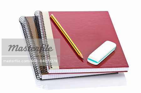 Pencil and eraser on a two notebooks reflected on white background. Shallow depth of field