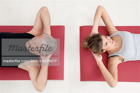 young woman and senior adult exercising in gym