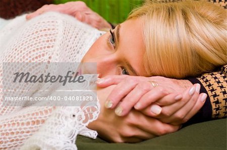 A young woman  laying her head on her grandmother's legs - part of a series.