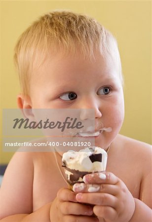 Dirty toddler boy easting ice cream - head and shoulders portrait