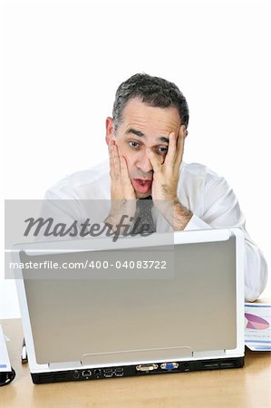 Stressed businessman sitting at his desk isolated on white background