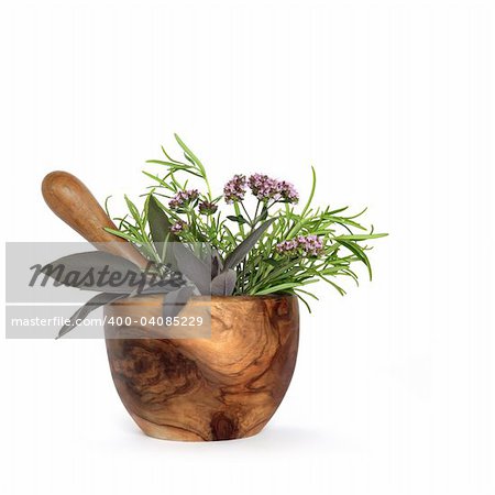 Rosemary, sage and marjoram herb leaves and flowers and an olive wood pestle and mortar, over white background.