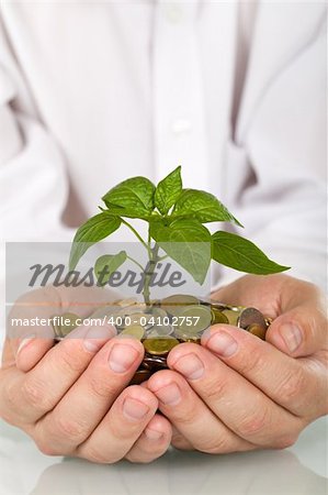Good investment and money making concept - businessman hands holding pland sprouting from a handful of coins