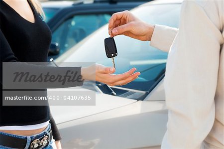 cropped view of man in car dealership giving car keys to client