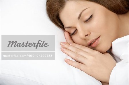 Portrait of the beautiful young woman sleeping in white bed