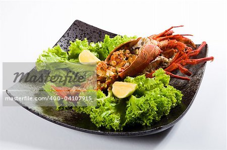 cooked large lobster in a bowl with lettuce and lemon