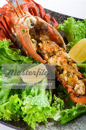 cooked large lobster in a bowl with lettuce and lemon