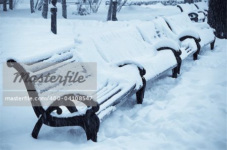 snow covered benches in the winter park