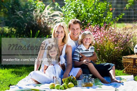 Smiling young family having picnic in a park