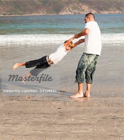 Young father and son playing on a beach