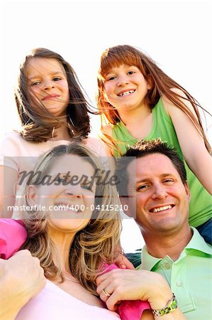 Portrait of happy family giving children shoulder rides