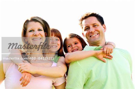 Portrait of happy family giving children piggy back rides