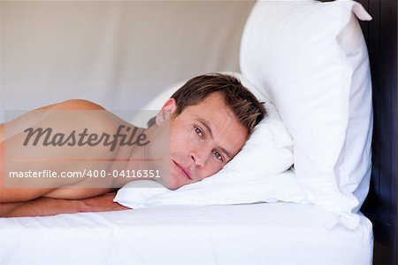 Attractive young man relaxing on bed