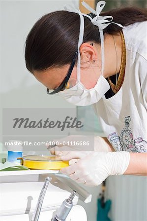 A young dentist seeking between her instruments.