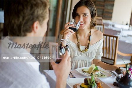 A young couple sitting together in a sophisticaed restaurant