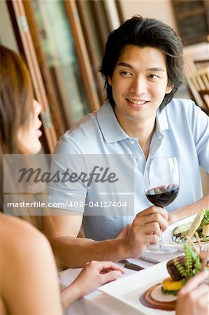 A young man enjoying wine with his meal