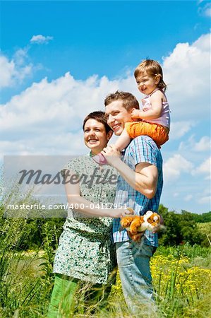 Parents and their daughter standing in the meadow