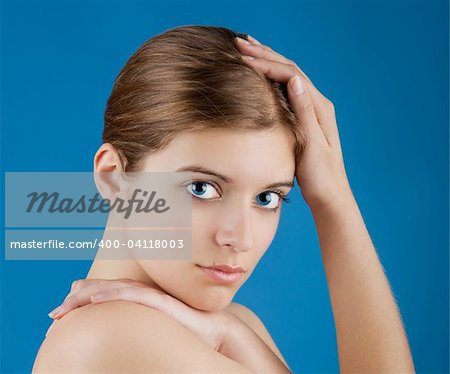 Close up portrait of a beautiful female model isolated on a blue background