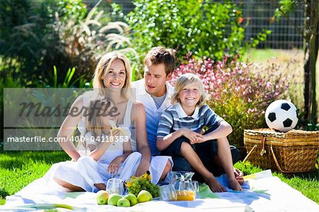 Smiling family picnicing in garden