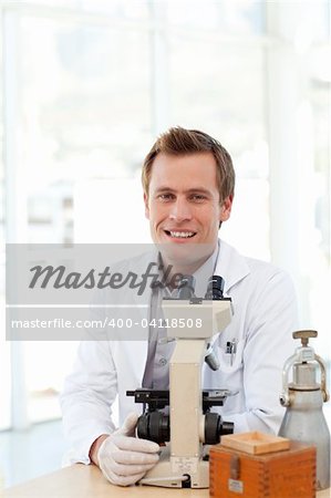 Male scientist looking at a slide under a microscope in a laboratory