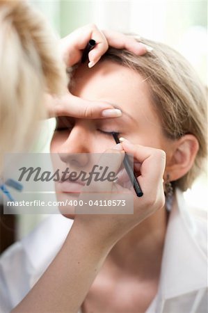 Image shows makeup process of an young nice girl