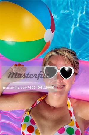 Laughing woman with sunglasses and inflatable toys