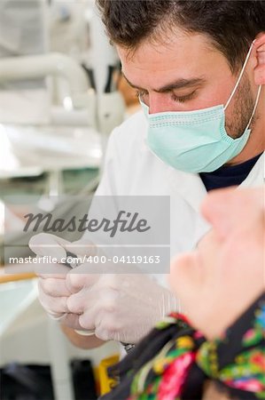 A young dentist preparing his turbine ( dental drill) for work - part of a series.