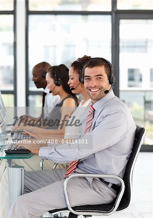 Friendly young businessman with folded arms in a call center