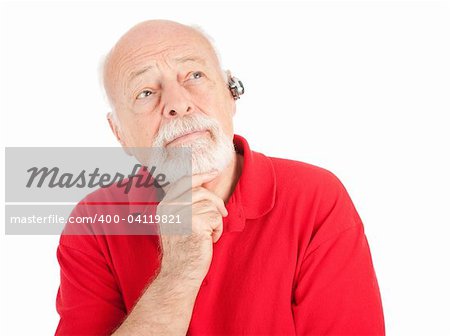 Senior man listening, using a hands-free set for his cellphone.  Isolated on white.