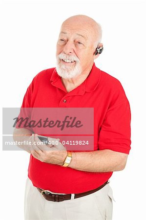 Senior man using a hands-free set to talk on his cellphone.  Isolated on white.