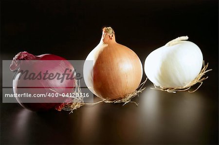 Three colorful different onion  in varied colors over black