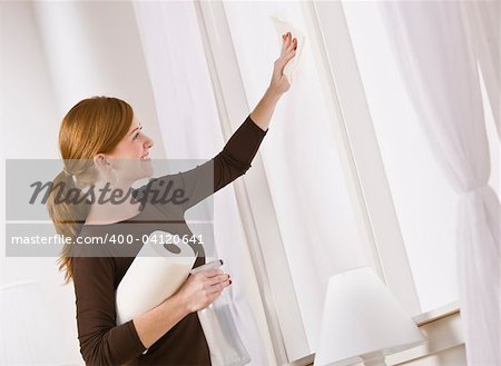 Attractive woman cleaning window holding paper towel. horizontal