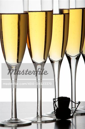 Champagne glasses and a cork in silhouette