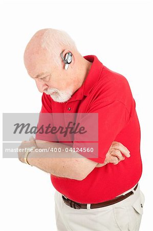 Senior man on the phone listening thoughtfully to someone on his hands free set.  Isolated on white.