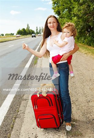 Mère et fille sur la route, faisant de l'auto-stop