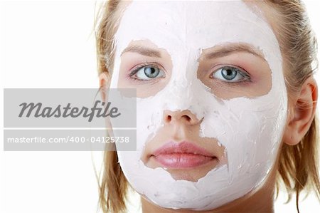 Kosmetik-Maske aus Ton auf dem jungen weiblichen Gesicht